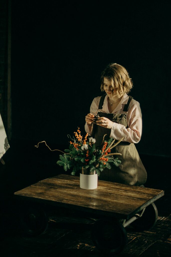 Woman Fixing Flowers in Vase